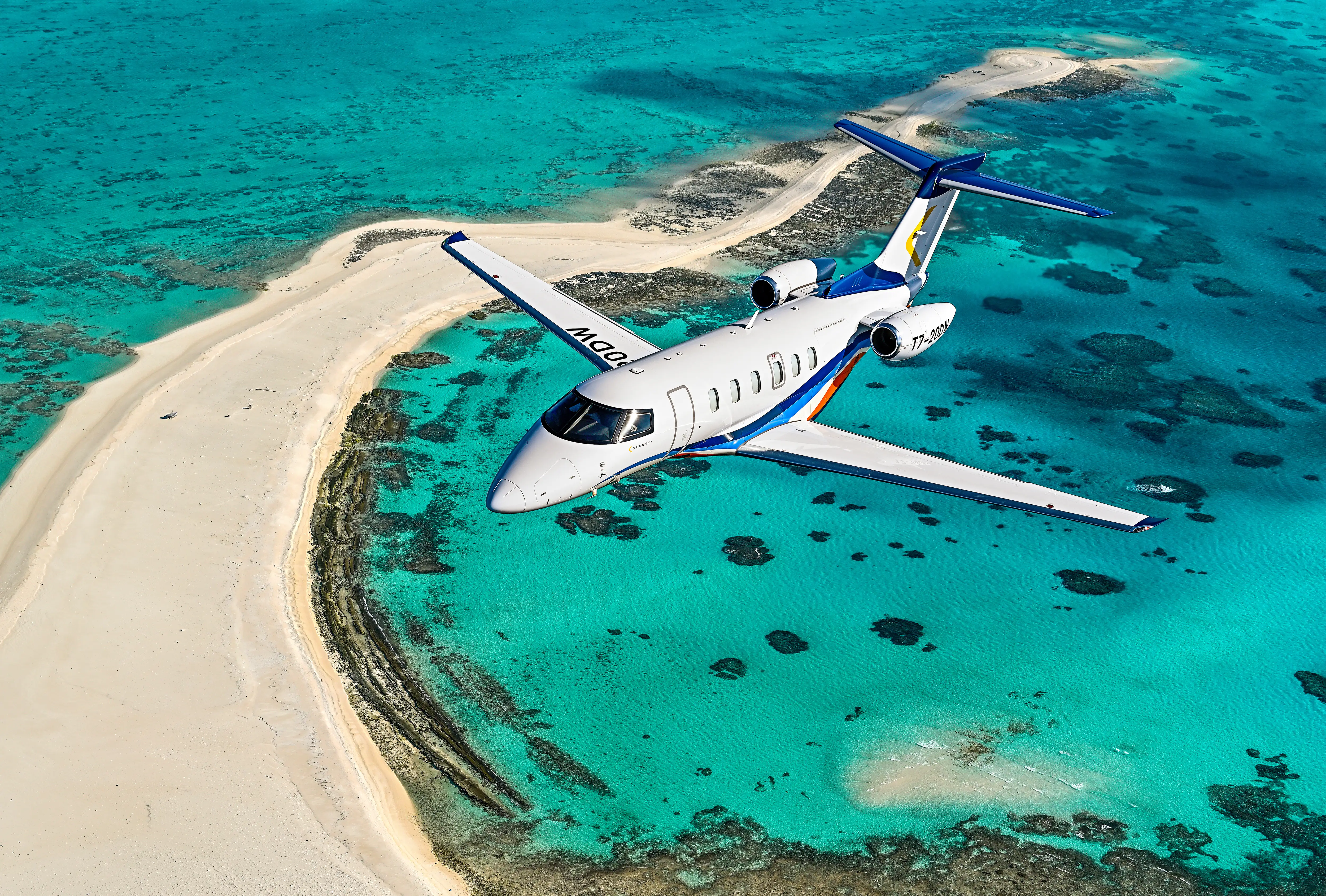 Private jet flying above clouds at golden hour